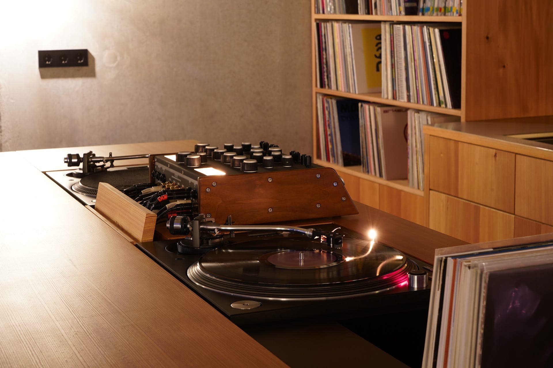 A vinyl turntable with vinyls records in the background